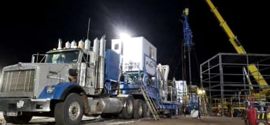 Foto: unidad de coiled tubing operando de noche junto a un pozo